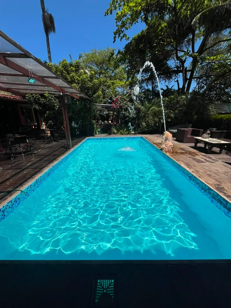 Piscina retangular limpa com fonte decorativa e água turquesa
