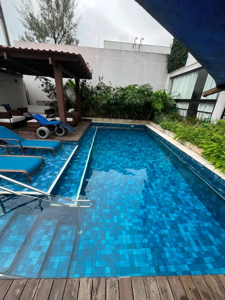 Piscina com pastilha azul mosaico e água limpa após manutenção da Standard Pool