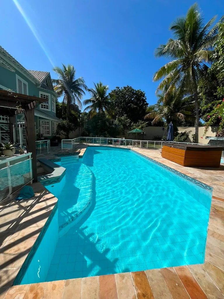 Piscina residencial de luxo com água clara e limpa, deck de pedra e área gourmet