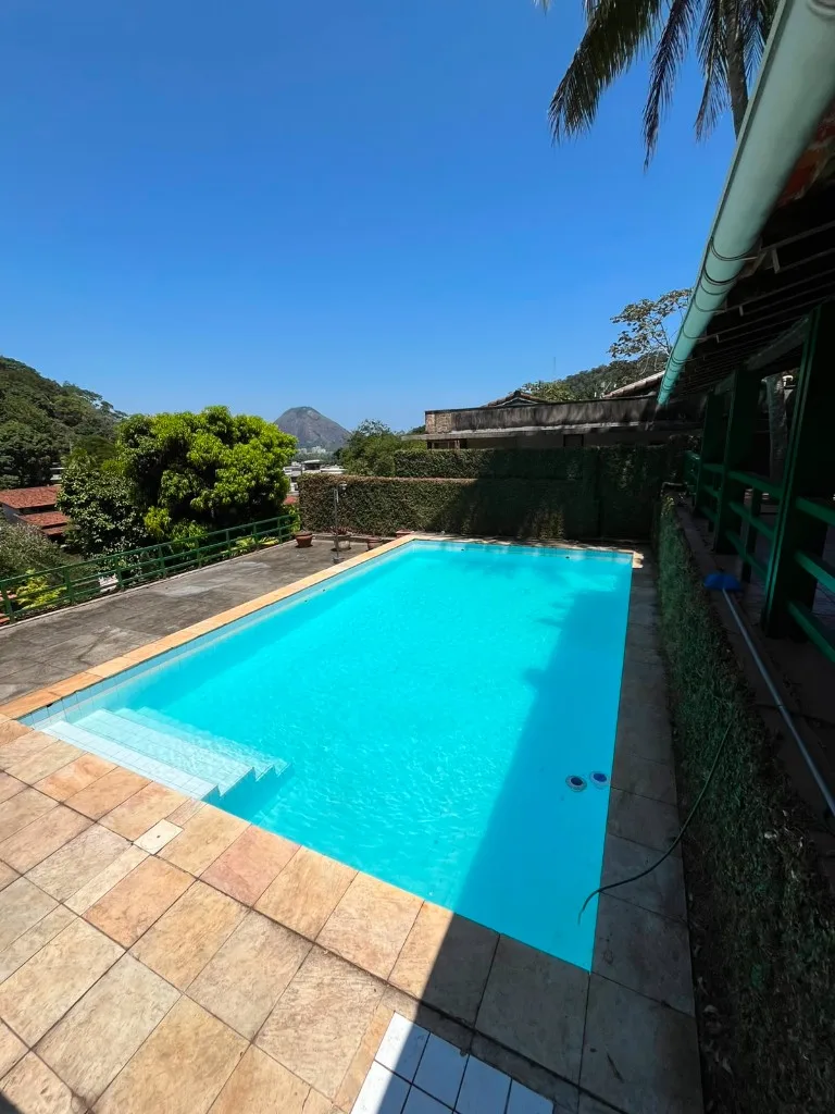 Piscina residencial com água cristalina e vista para a montanha, após limpeza da Standard Pool